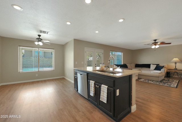 kitchen with sink, french doors, ceiling fan, stainless steel dishwasher, and a kitchen island with sink