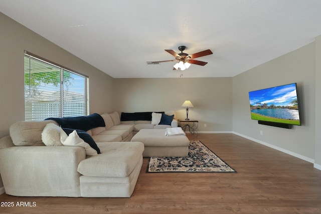 living room with dark wood-type flooring and ceiling fan