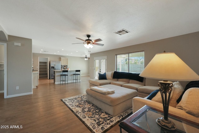 living room with hardwood / wood-style flooring, a textured ceiling, french doors, and ceiling fan