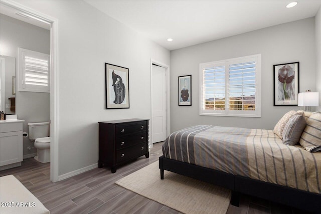 bedroom with connected bathroom, a closet, and light wood-type flooring