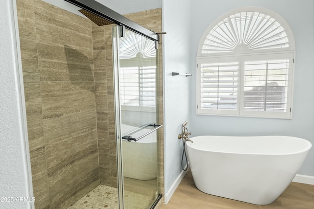 6920 W Via Montoya Dr, Glendale, AZ 85310 - bathroom featuring a freestanding bath, baseboards, a shower stall, and wood finished floors