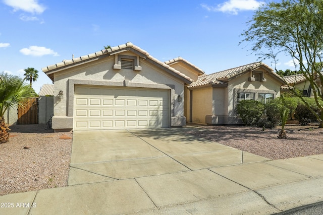 6920 W Via Montoya Dr, Glendale, AZ 85310 - mediterranean / spanish house featuring concrete driveway, a tile roof, a garage, and stucco siding