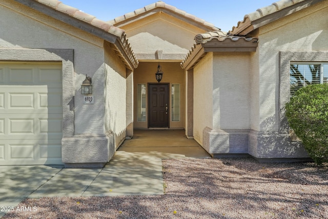 6920 W Via Montoya Dr, Glendale, AZ 85310 - entrance to property featuring a tiled roof, a garage, and stucco siding