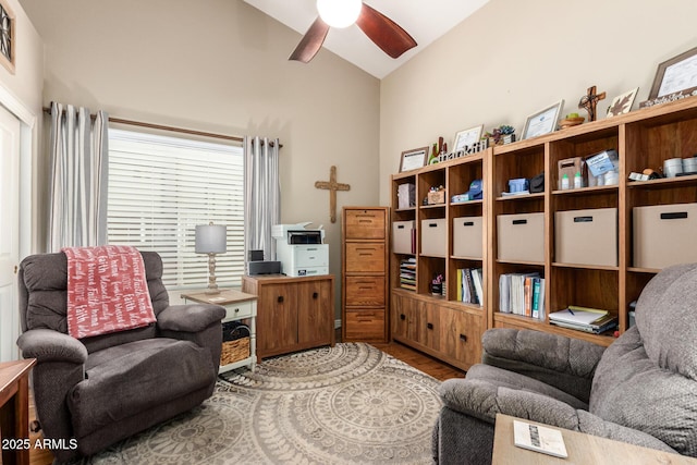 living area with a ceiling fan, vaulted ceiling, and wood finished floors