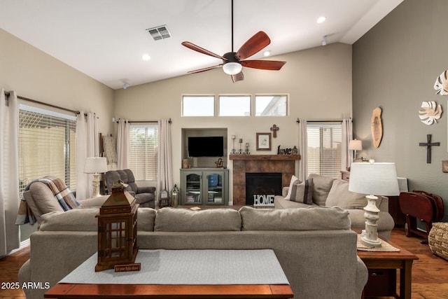 living room with recessed lighting, wood finished floors, visible vents, a ceiling fan, and a tiled fireplace