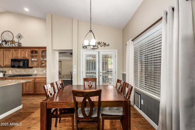 dining space featuring high vaulted ceiling, french doors, and dark wood finished floors