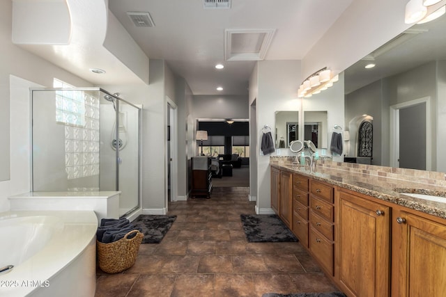 bathroom with double vanity, a shower stall, visible vents, and recessed lighting