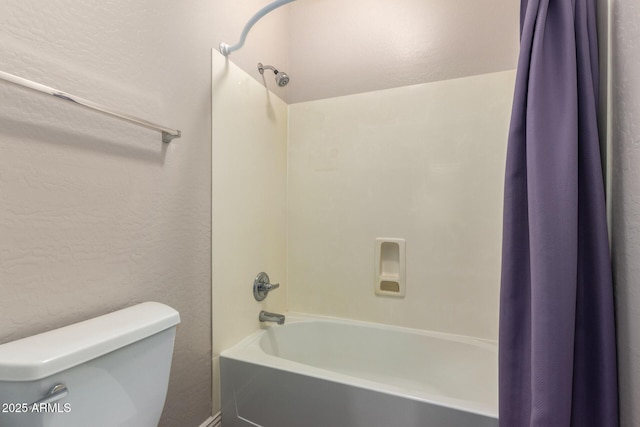 full bath with toilet, shower / bathtub combination with curtain, and a textured wall