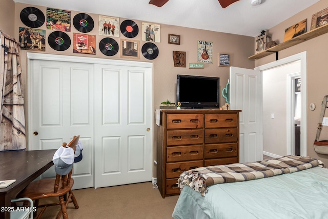 bedroom with a ceiling fan, a closet, and light colored carpet