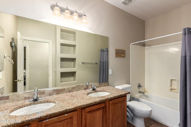 bathroom featuring toilet, double vanity, a sink, and visible vents