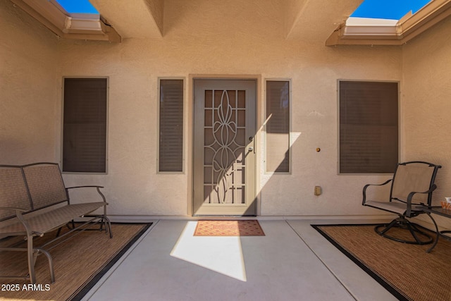 entrance to property with a patio area and stucco siding