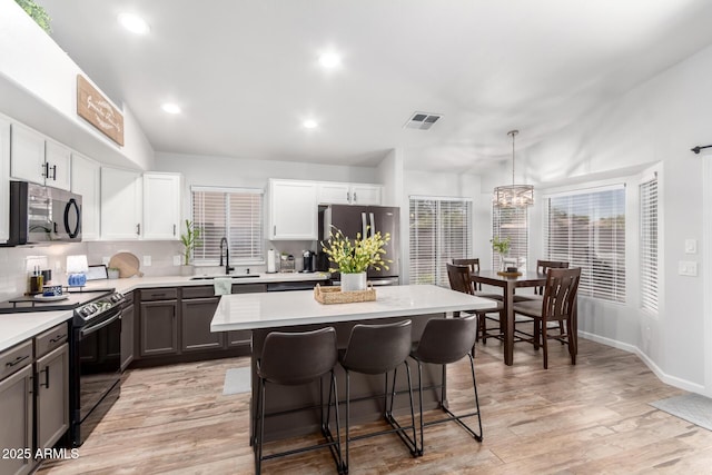 510 S Saddle St, Gilbert, AZ 85233 - kitchen featuring a kitchen breakfast bar, light countertops, visible vents, freestanding refrigerator, and electric range