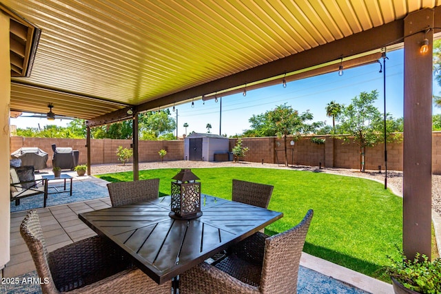 510 S Saddle St, Gilbert, AZ 85233 - view of patio / terrace featuring a fenced backyard, an outbuilding, outdoor dining space, and a shed