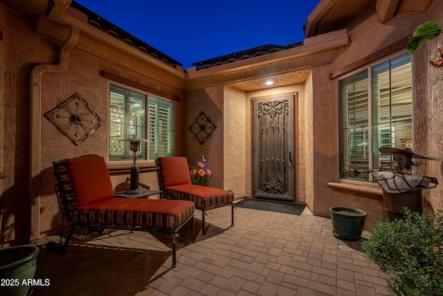 exterior entry at night with a patio area