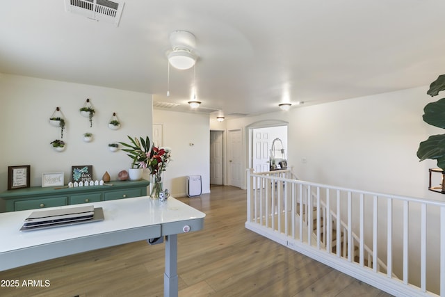 interior space featuring green cabinets, a peninsula, wood finished floors, and visible vents