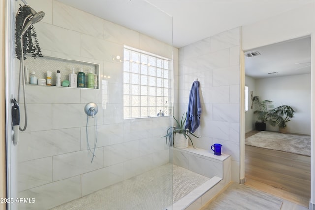 bathroom with wood finished floors, visible vents, and a walk in shower