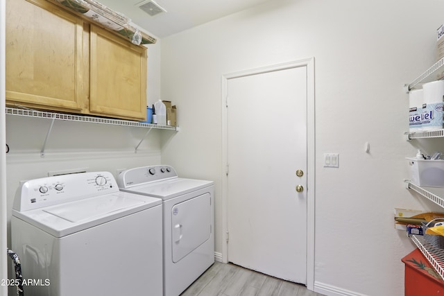 laundry area featuring cabinet space, visible vents, separate washer and dryer, and light wood finished floors