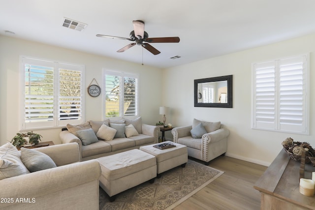 living area with light wood-style floors, plenty of natural light, and visible vents