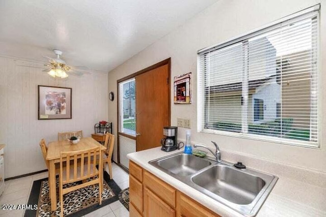 kitchen featuring sink, ceiling fan, and light tile patterned flooring