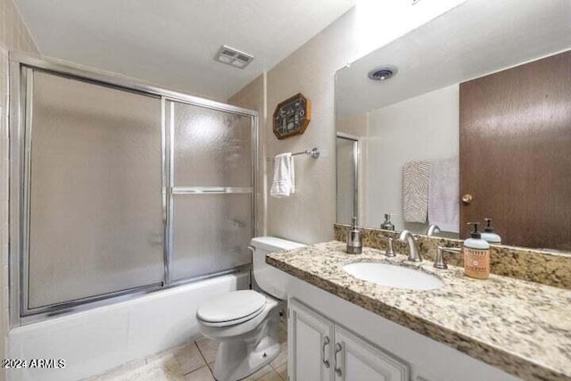 full bathroom featuring enclosed tub / shower combo, vanity, toilet, and tile patterned flooring