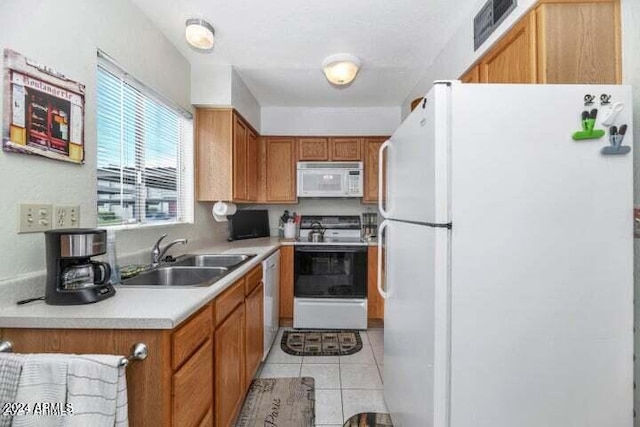 kitchen featuring sink, white appliances, and light tile patterned floors