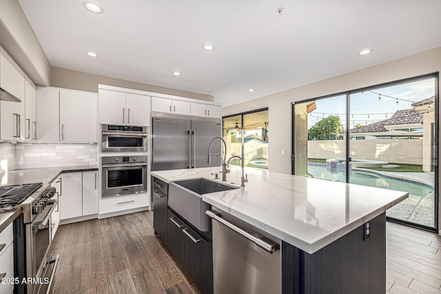 7439 E Beryl Ave, Scottsdale, AZ 85258 - kitchen with premium appliances, a sink, white cabinetry, wood finished floors, and recessed lighting