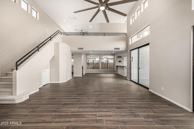 7439 E Beryl Ave, Scottsdale, AZ 85258 - unfurnished living room featuring a towering ceiling, ceiling fan, wood finished floors, plenty of natural light, and baseboards