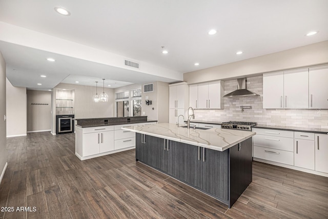 7439 E Beryl Ave, Scottsdale, AZ 85258 - kitchen with a sink, wall chimney range hood, a center island with sink, beverage cooler, and dark wood-type flooring