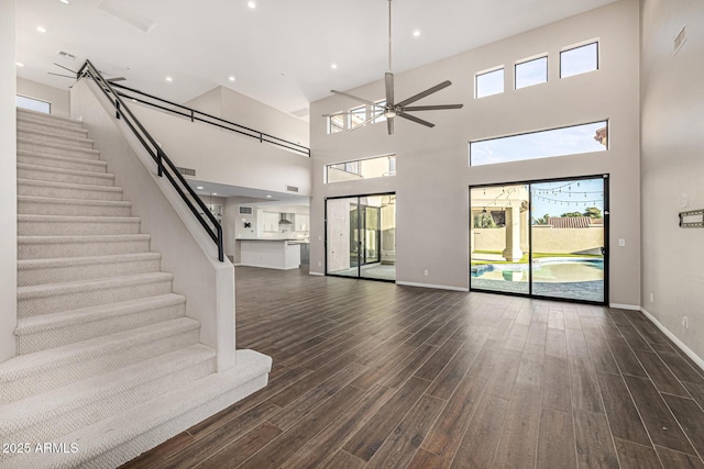 7439 E Beryl Ave, Scottsdale, AZ 85258 - unfurnished living room with dark wood-style floors, stairs, a high ceiling, baseboards, and ceiling fan