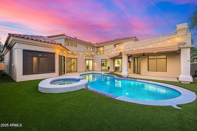 7439 E Beryl Ave, Scottsdale, AZ 85258 - back of house featuring stucco siding, a patio, a yard, a pool with connected hot tub, and a tiled roof