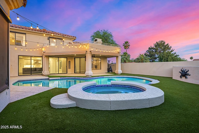 7439 E Beryl Ave, Scottsdale, AZ 85258 - pool at dusk featuring a pool with connected hot tub and a patio area