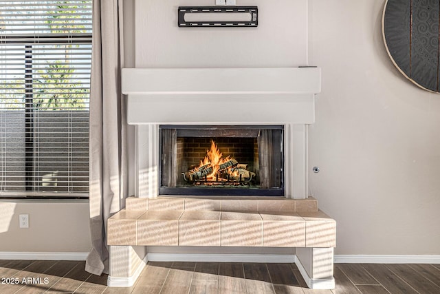 7439 E Beryl Ave, Scottsdale, AZ 85258 - detailed view of wood finished floors, baseboards, and a warm lit fireplace