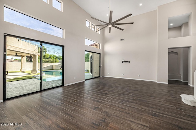 7439 E Beryl Ave, Scottsdale, AZ 85258 - unfurnished living room with a high ceiling, baseboards, ceiling fan, dark wood-style floors, and recessed lighting