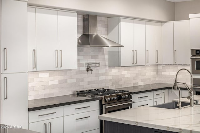 7439 E Beryl Ave, Scottsdale, AZ 85258 - kitchen with wall chimney exhaust hood, appliances with stainless steel finishes, a sink, dark stone counters, and white cabinetry