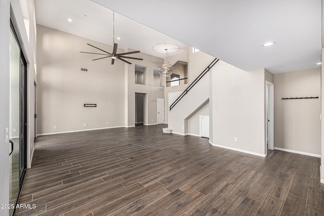 7439 E Beryl Ave, Scottsdale, AZ 85258 - unfurnished living room featuring dark wood-style floors, a ceiling fan, baseboards, recessed lighting, and a towering ceiling
