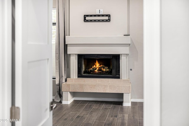 7439 E Beryl Ave, Scottsdale, AZ 85258 - detailed view of wood tiled floors, baseboards, and a warm lit fireplace