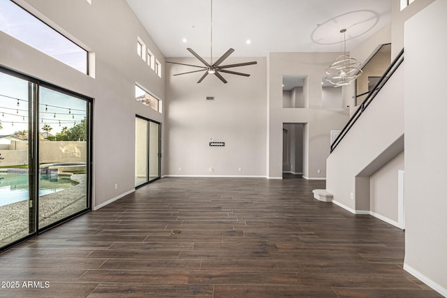7439 E Beryl Ave, Scottsdale, AZ 85258 - unfurnished living room featuring dark wood-style flooring, ceiling fan, a high ceiling, stairs, and baseboards