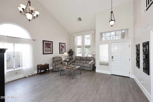 living room featuring hardwood / wood-style floors, a chandelier, and high vaulted ceiling