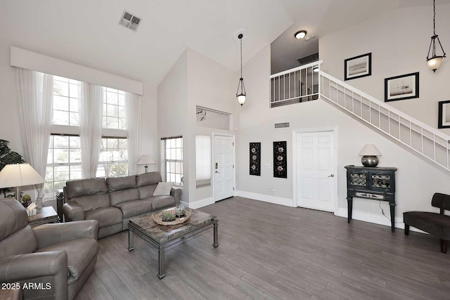 living room featuring a towering ceiling and dark hardwood / wood-style floors