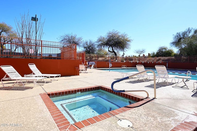 view of swimming pool featuring a patio and a hot tub