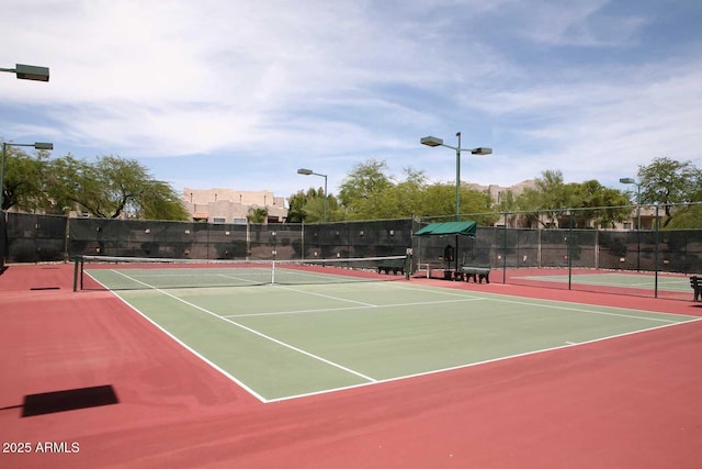 view of tennis court featuring basketball hoop