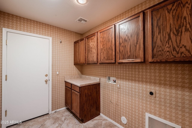 clothes washing area featuring hookup for a washing machine, hookup for an electric dryer, light tile patterned floors, and cabinets