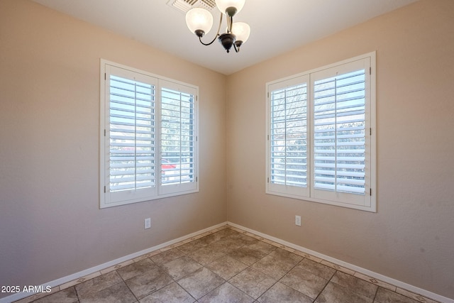 spare room with a notable chandelier