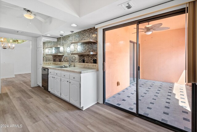 interior space with ceiling fan, sink, tasteful backsplash, and light hardwood / wood-style flooring