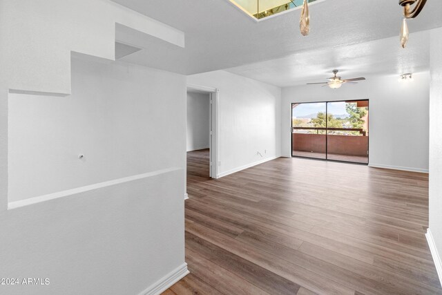 empty room with hardwood / wood-style floors, ceiling fan, and a textured ceiling