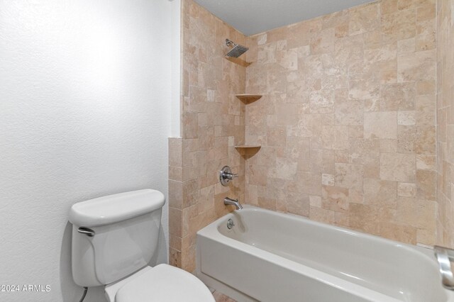 bathroom featuring tiled shower / bath and toilet