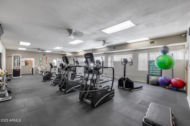 workout area with a textured ceiling and ceiling fan