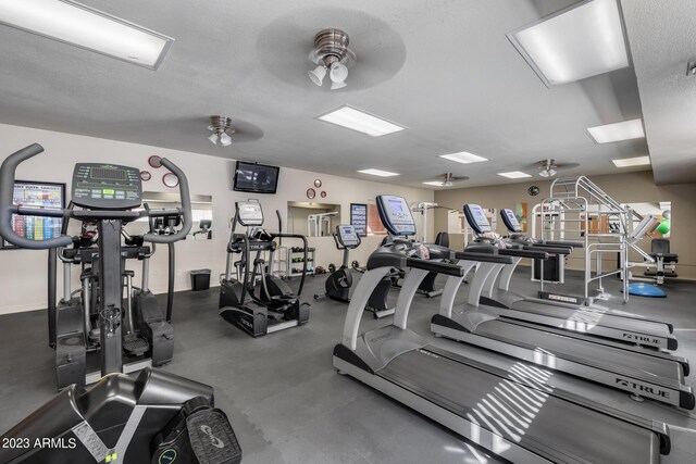 exercise room featuring a textured ceiling and ceiling fan