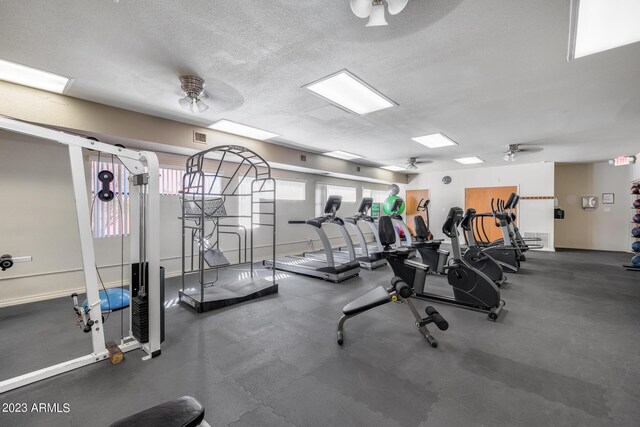 workout area featuring a textured ceiling and ceiling fan