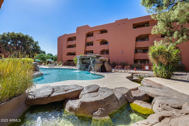 view of swimming pool with pool water feature